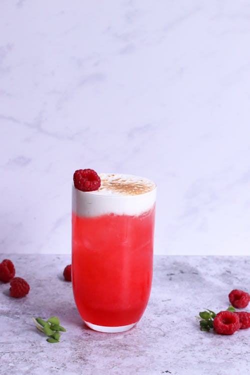 Free Glass of tasty beverage with fresh strawberry and cinnamon powder on froth on marble surface Stock Photo