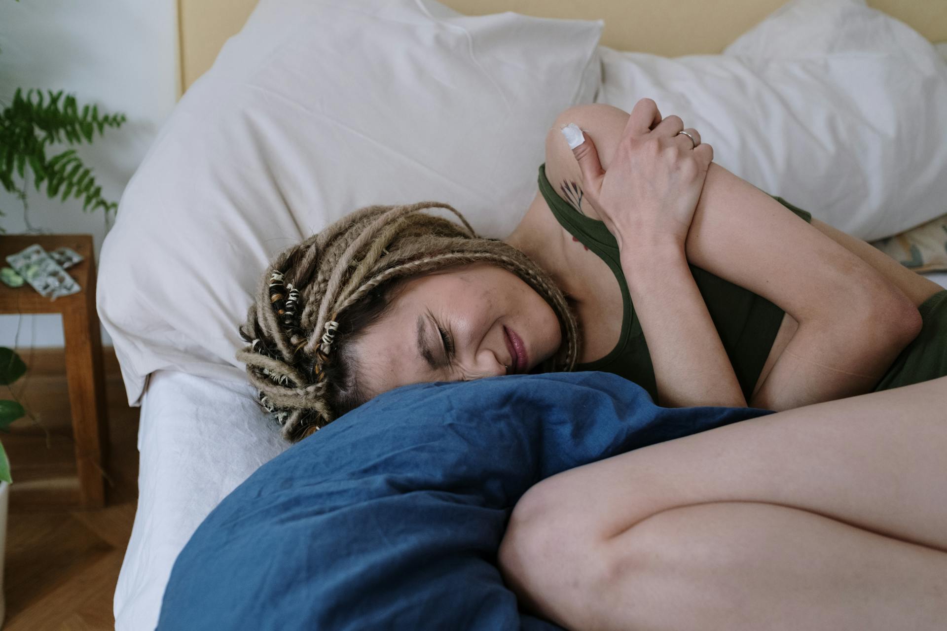 Woman Suffering from a Stomach Pain Lying Down on Bed