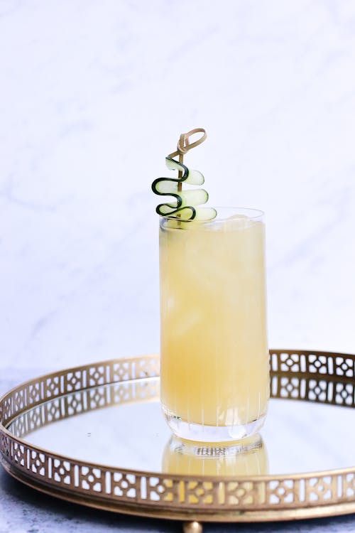 Glass of cold ginger drink on ornamental tray