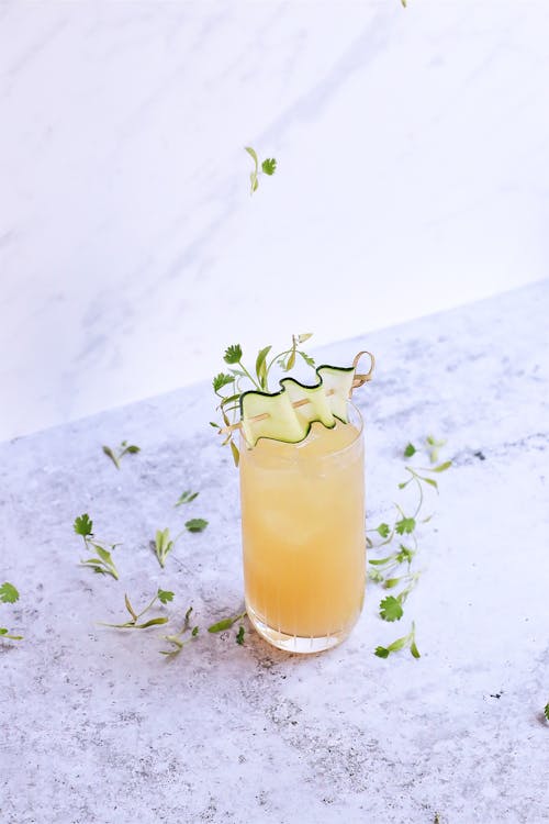 Glass of sour ginger cocktail on marble table