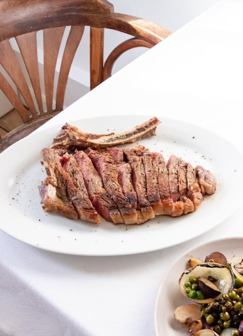 Free Appetizing cut ribeye steak served on restaurant table Stock Photo