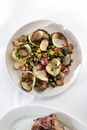 Tasty mussels with green peas served on plate