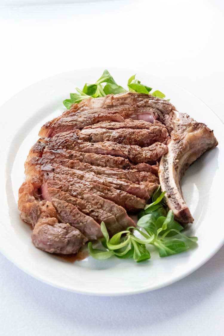 Appetizing Steak On Salad Leaves In Restaurant