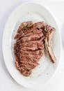 Overhead appetizing grilled ribeye steak cut on plate and served in light room