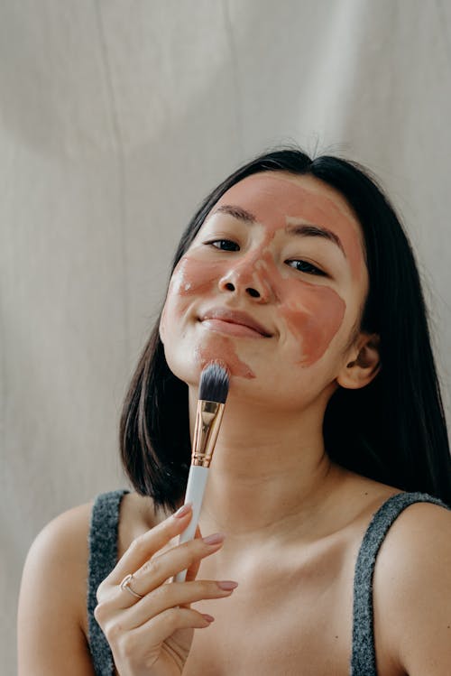 Free A Beautiful Woman Applying Clay Mask on Her Face Stock Photo