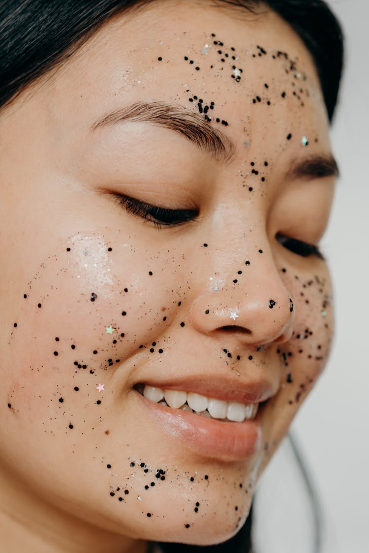 A Close-up Shot Of A Smiling Woman With Glitter Mask On Her Face