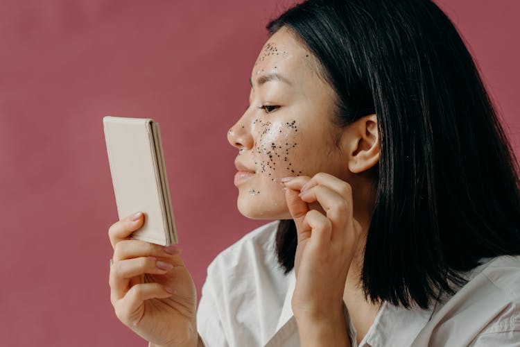 A Young Woman Peeling Off A Glittery Facial Mask