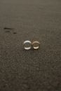 2 Silver and Gold Round Coins on Brown Sand