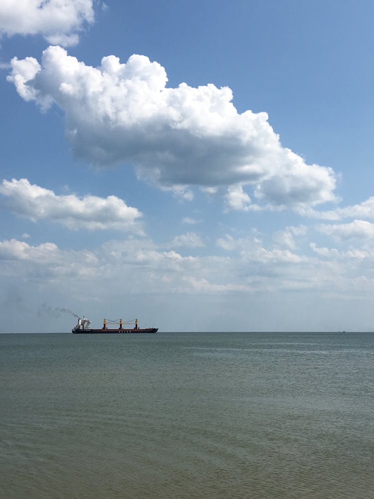 A Sailing Ship On The Sea Under The White Clouds And Blue Sky