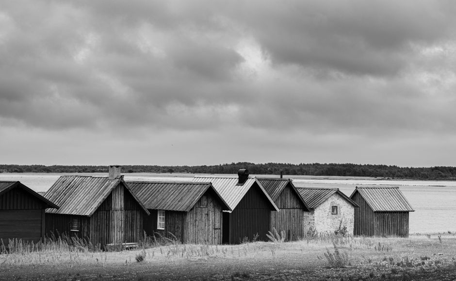 A serene black and white view of traditional wooden houses on Fårö island, Sweden.
