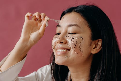 A Woman Peeling a Glitter Mask on Her Face