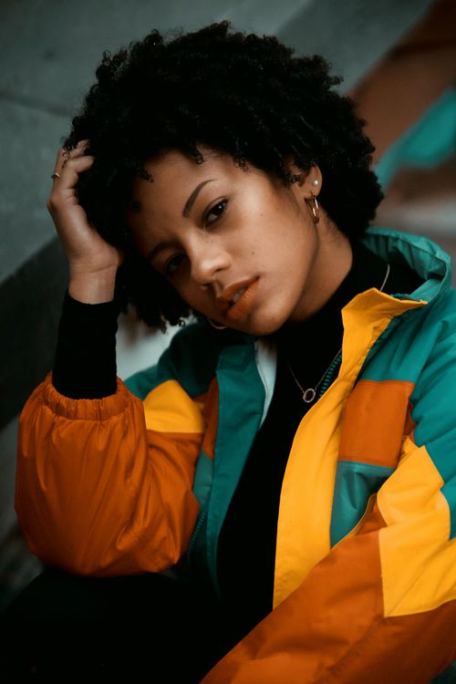 Free Portrait of a fashionable young woman in a colorful jacket posing outdoors in Montreal. Stock Photo