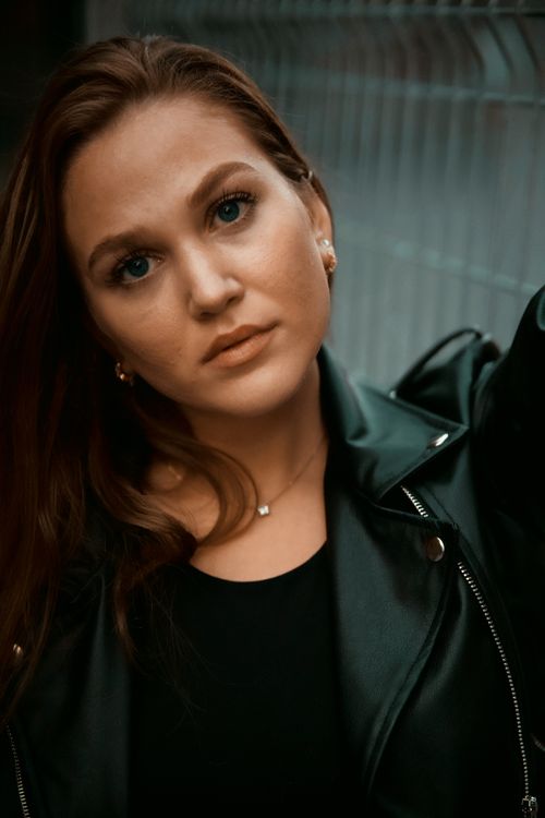 Free Close-up portrait of a woman in a black leather jacket with a serious expression. Stock Photo