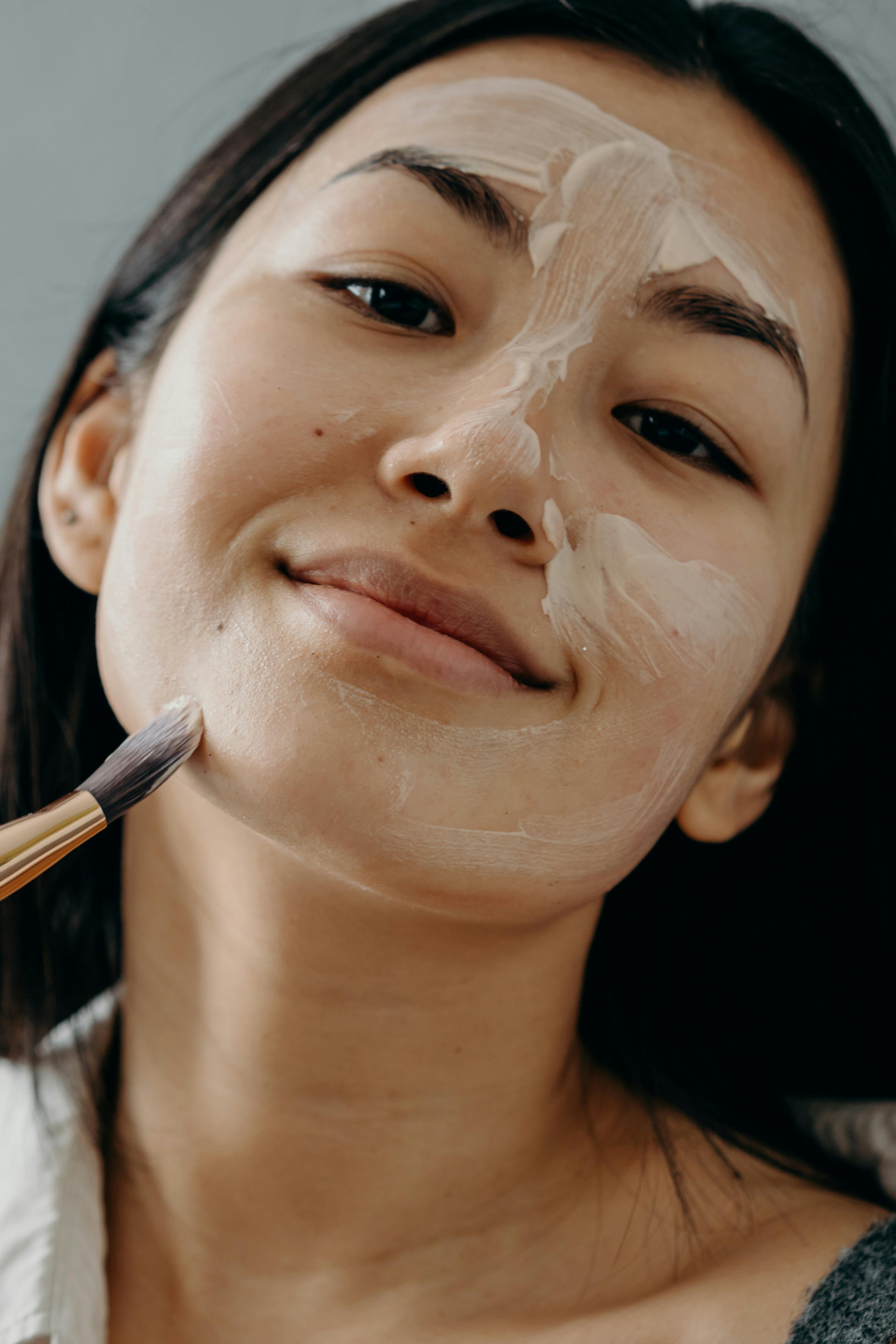 a woman applying a cream on her face