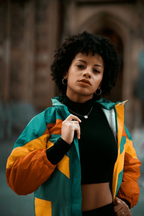 Free Woman posing confidently in colorful street fashion in Montreal, Canada, with a blurred background. Stock Photo