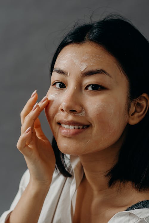 Free A Smiling Woman Touching Her Face Stock Photo