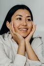 A Smiling Woman Touching Her Face with Cream