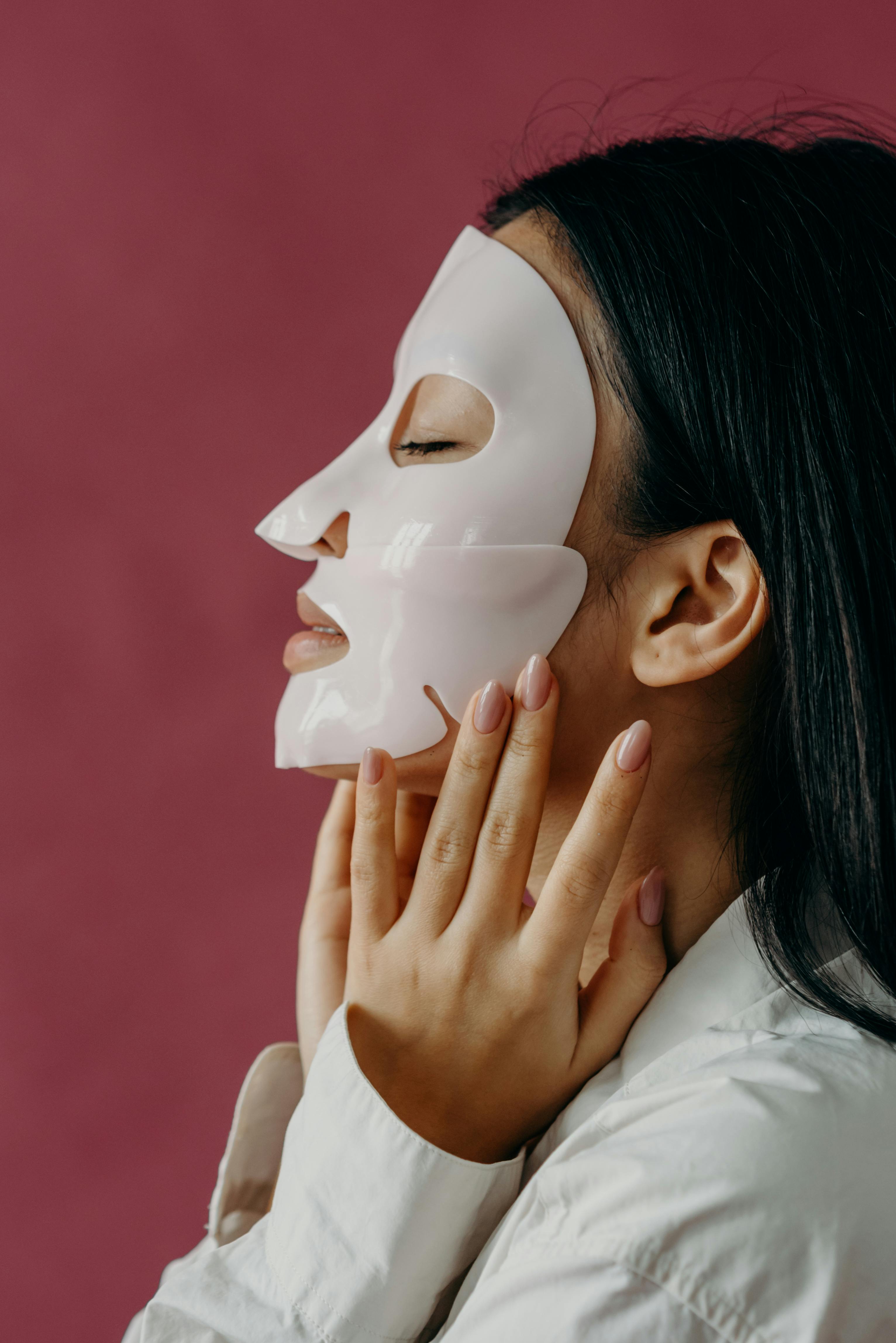 a side view of a woman in white long sleeves with mask on her face