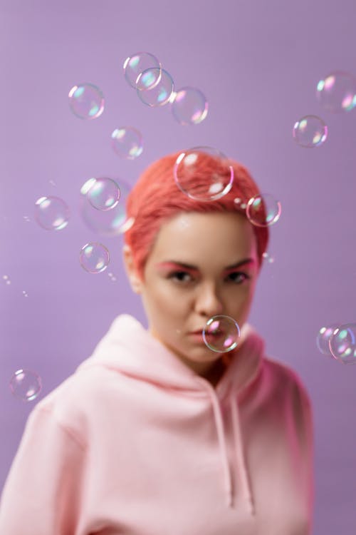  Bubbles in Front of a Woman in a Pink Hoodie
