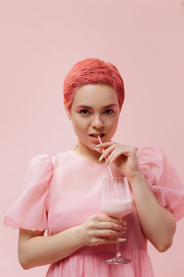 A Woman With Pink Hair While Drinking Strawberry Milkshake 