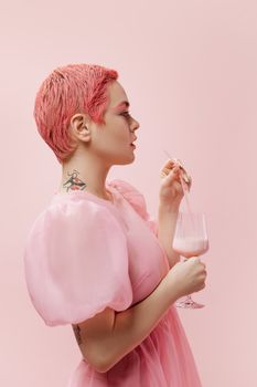 Artistic side profile of a woman with pink hair enjoying a strawberry milkshake.