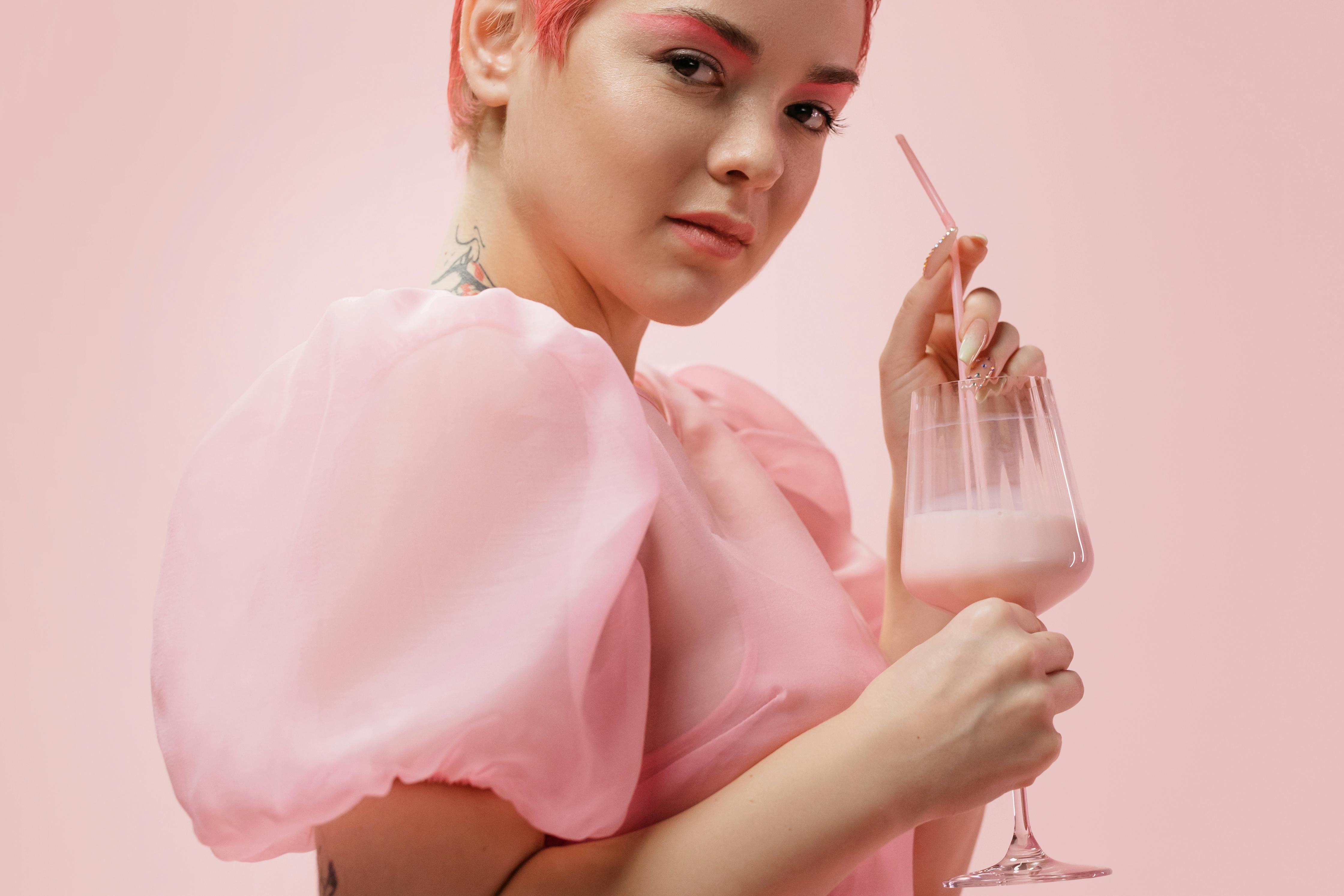 Portrait of a woman in pink enjoying a strawberry milkshake, capturing a vibrant and modern aesthetic.