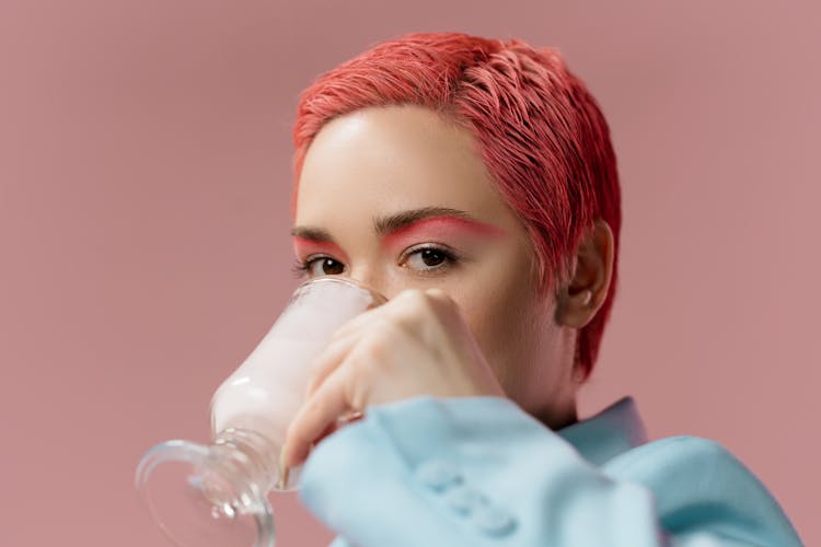 Woman With Pink Hair Drinking From A Glass