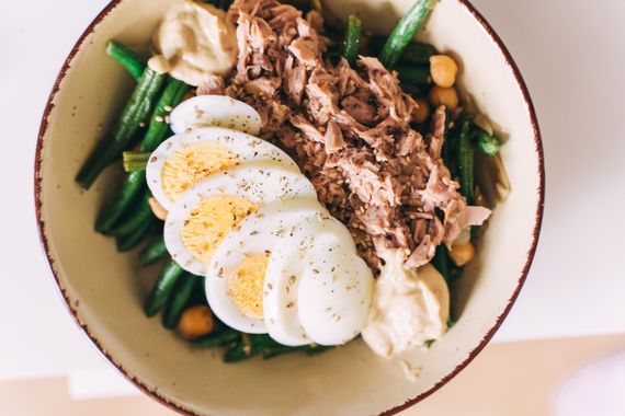 Prato com atum, feijão verde e ovo cozido cortado ao meio — combinação de fontes de proteína animal