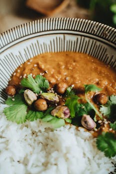 A vegan dahl served with rice, pistachios, and fresh cilantro for a healthy meal.