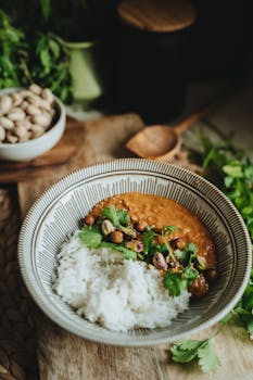 A bowl of vegan lentil curry with rice garnished with cilantro, perfect for a healthy meal.