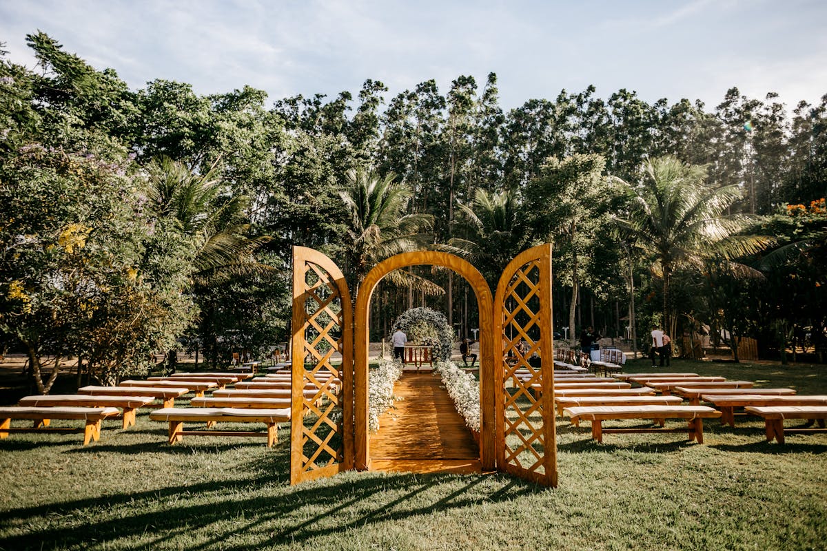 Wedding arch and guest benches placed in verdant park