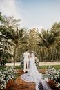 Unrecognizable elegant couple standing near floral arbor during wedding ceremony