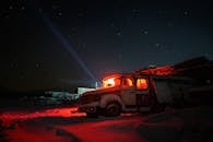 Old Truck Lit from Inside Parked in Front of an Abandoned Building on a Winter Night