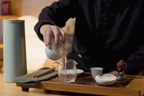 Free A serene traditional tea ceremony featuring a porcelain tea set and pouring water. Stock Photo