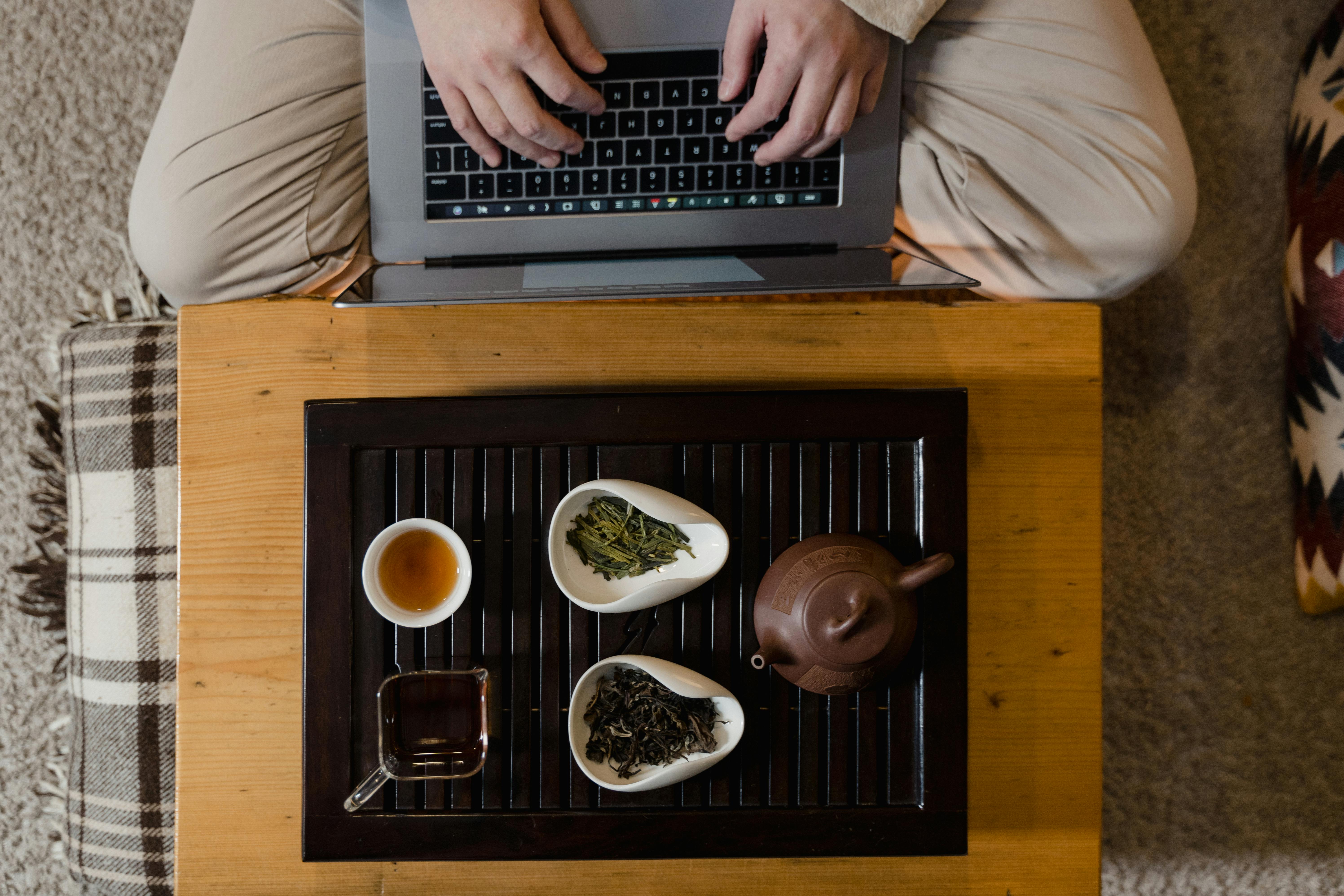 Cozy setting with laptop and traditional tea set, perfect for relaxation and work.