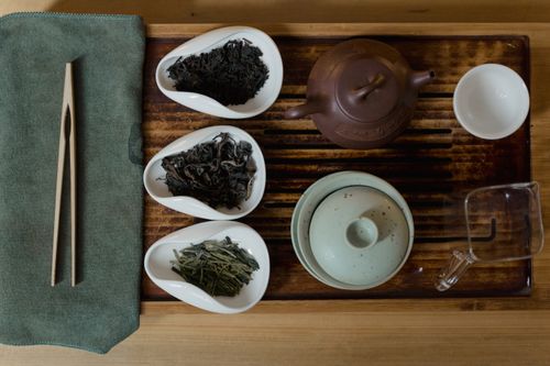 Free Artistic setup of a traditional Asian tea ceremony with cups, teapots, and tea leaves. Stock Photo