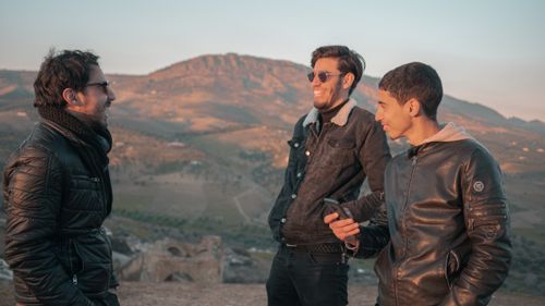 Free Three young men laughing and enjoying the outdoors in Fes, Morocco. Stock Photo