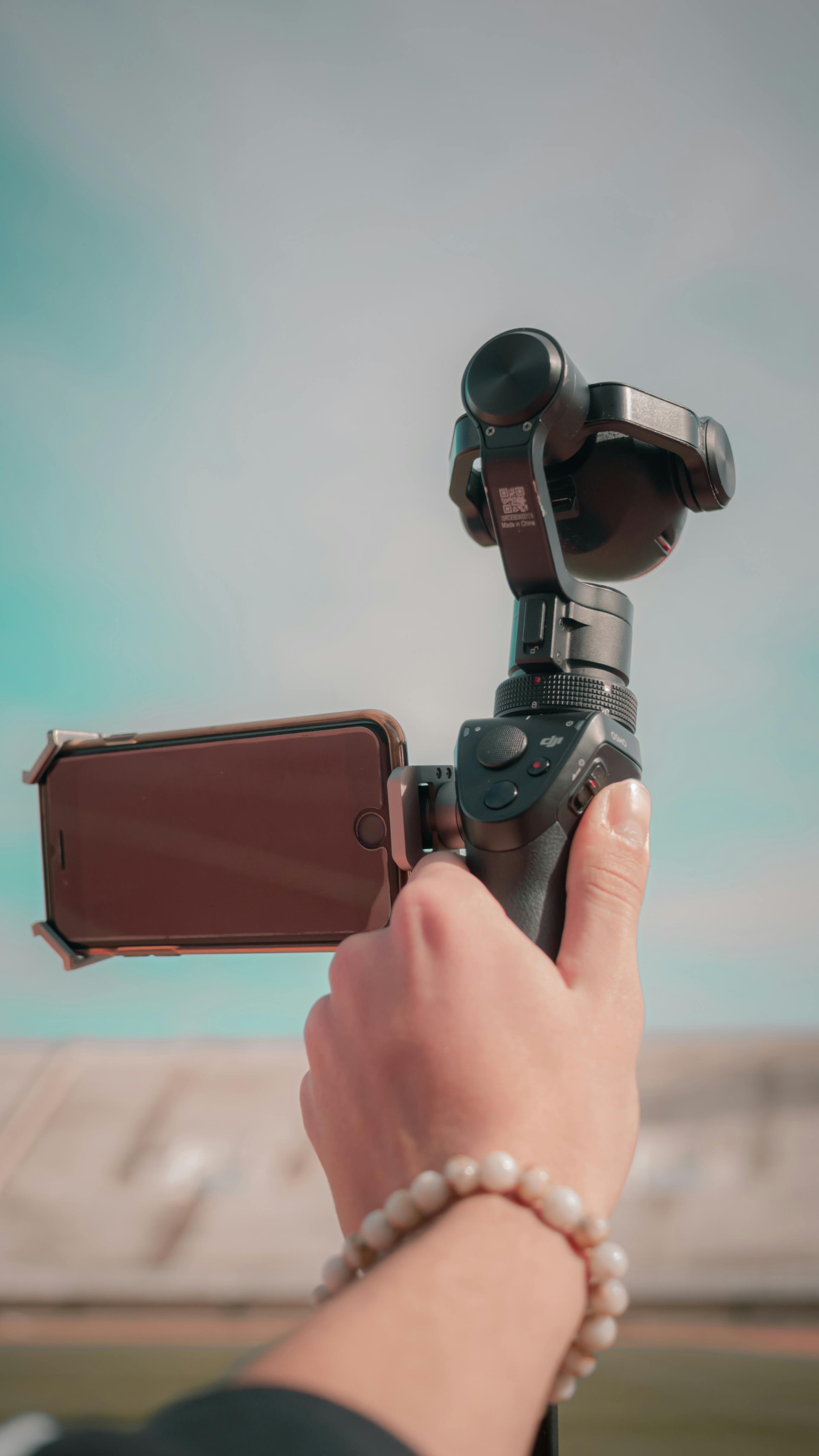 a person holding an osmo mobile with cellphone