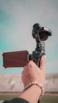 Hand holding a gimbal with smartphone attached, capturing a scene outdoors in Fes, Morocco.