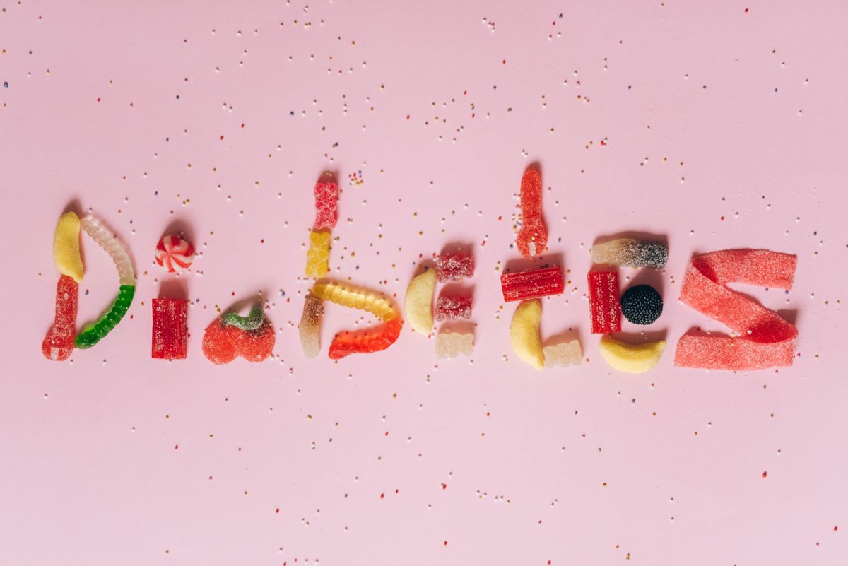 Candies shaped to spell diabetes on a pink background, highlighting sugar intake