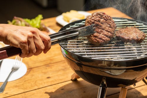 Person Holding a Stainless Tong with Hamburger