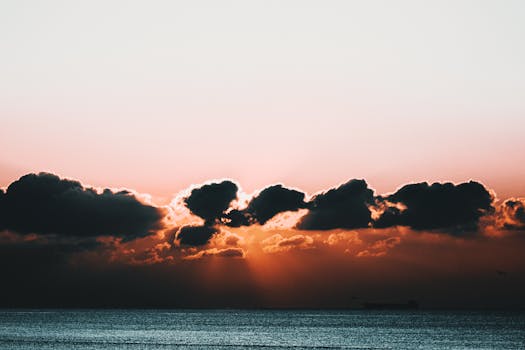 A captivating sunset scene over the ocean with dramatic clouds and warm hues.