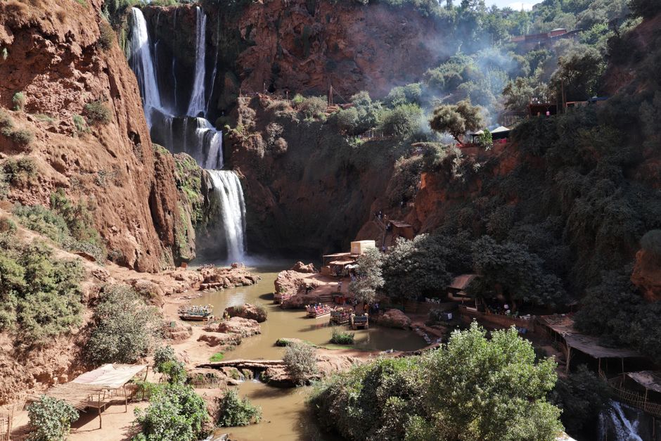 Stunning waterfall cascading through rocky cliffs surrounded by vibrant greenery in a tranquil canyon.