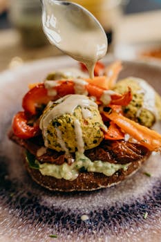 A delicious vegan falafel burger with fresh vegetables and tahini sauce, perfect for a healthy meal.