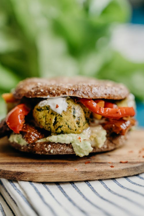 Free Vegan Falafel Burger on Wooden Plate Stock Photo