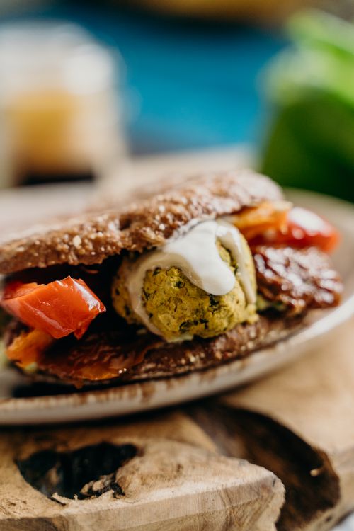 Free Delicious vegan falafel sandwich with fresh tomatoes and sauce. Stock Photo