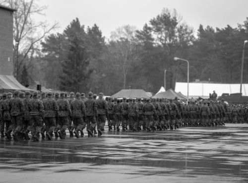 Free A group of soldiers in uniform marching together outdoors in a black and white photograph. Stock Photo