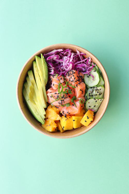 Bowl with delicious vegetables and diced raw fish
