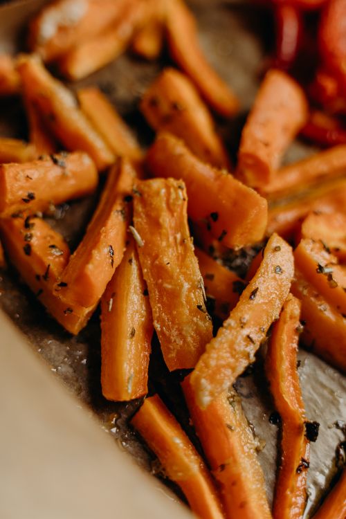 Free Delicious roasted carrot sticks with herbs, perfect for a healthy vegan recipe. Stock Photo