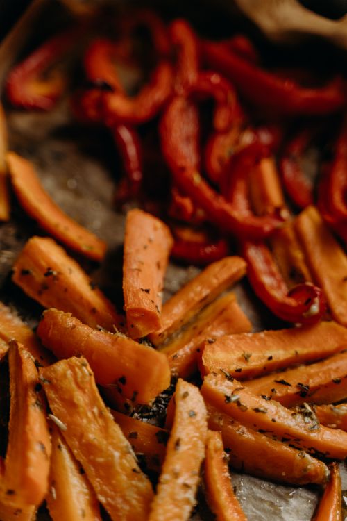 Free Delicious roasted carrots and bell peppers seasoned with herbs. Perfect for healthy vegetarian meals. Stock Photo
